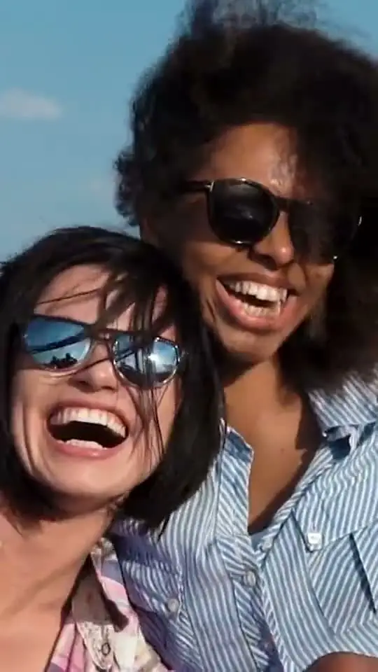 A clip frame: two friends laughing at the camera